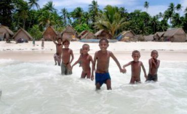 a group of children standing in the water