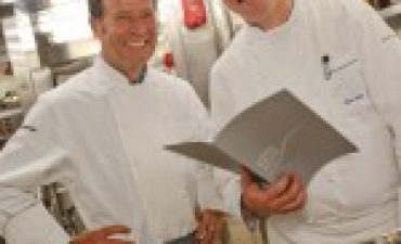 a couple of chefs in a kitchen