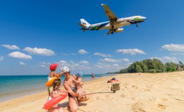 Family taking a picture, airplane in the background