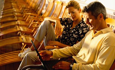 Couple on a laptop on deck