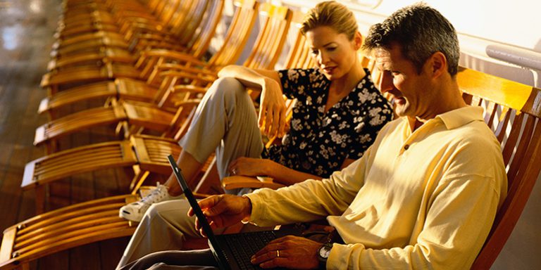 Couple on a laptop on deck