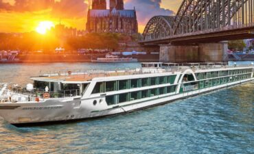 Cruise ship in river below a bridge