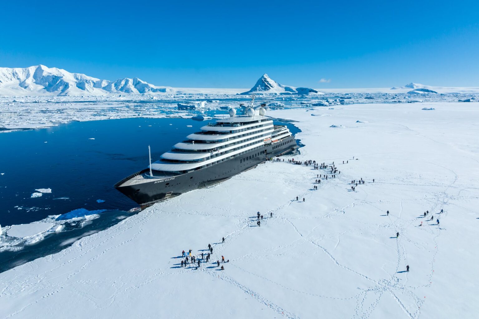 Scenic Eclipse and guest steping on the fast Ice at Hanusse Bay