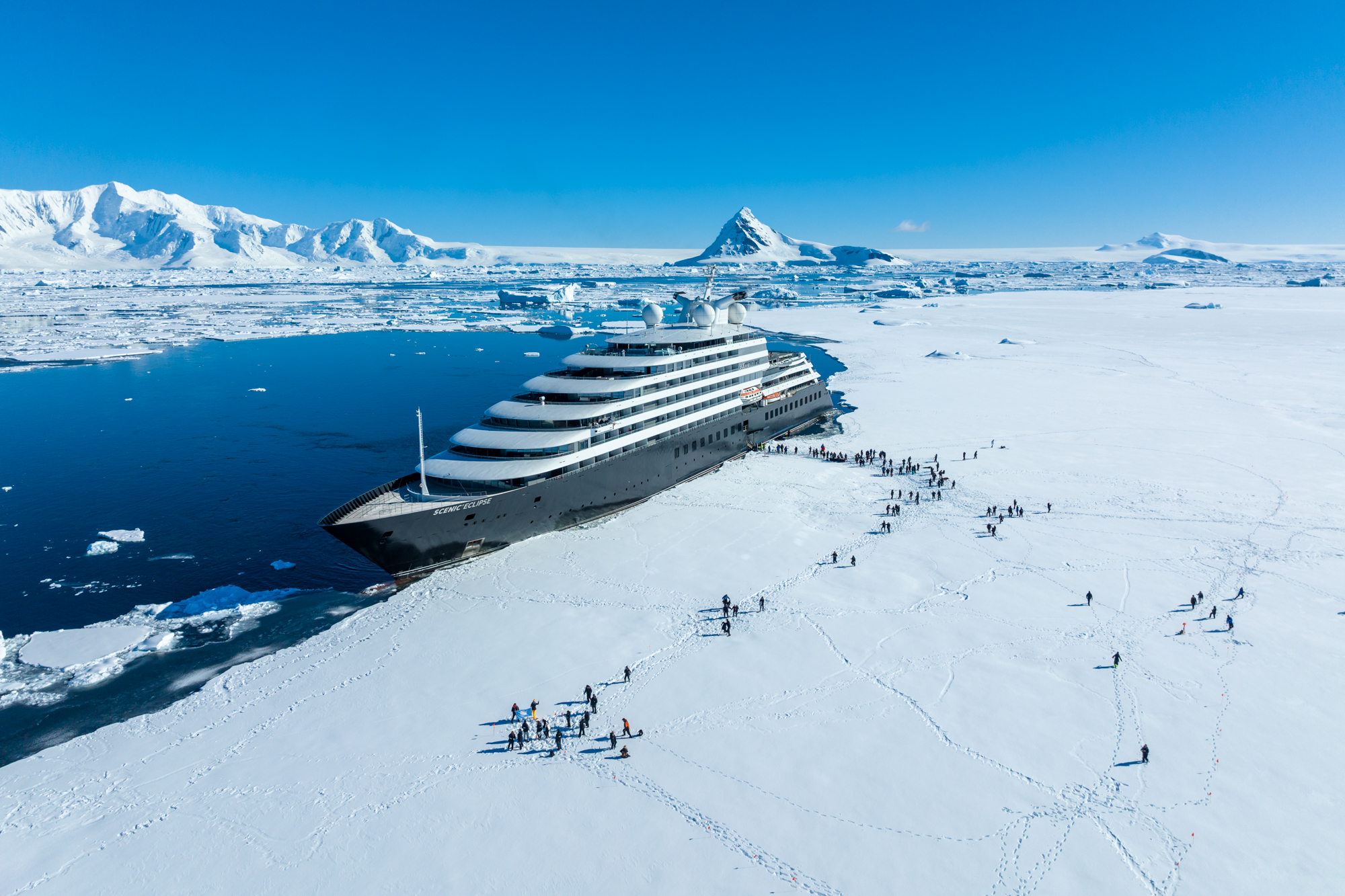 Scenic Eclipse and guest steping on the fast Ice at Hanusse Bay