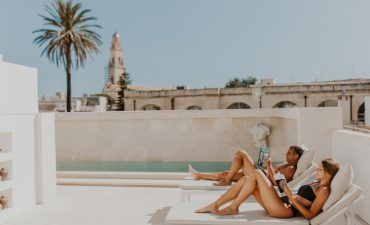 Man and woman reading magazine by the pool