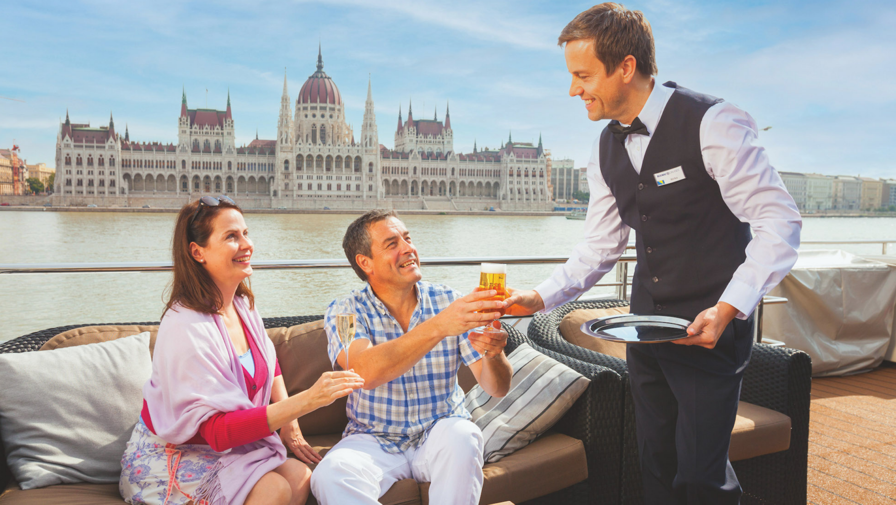 A couple being served on a Scenic ship by a butler
