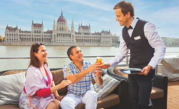 A couple being served on a Scenic ship by a butler