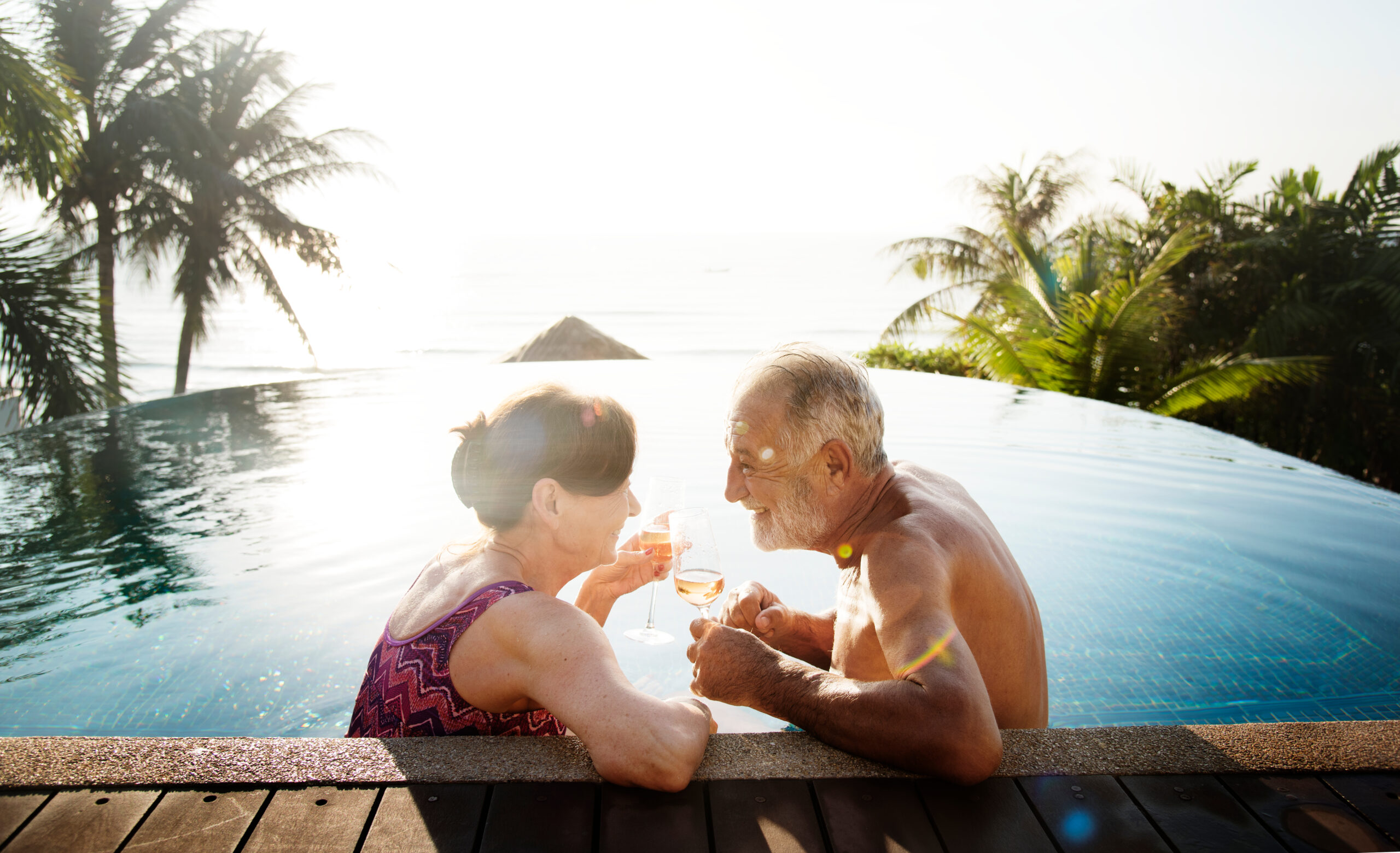 Elderly Couple in Pool with Wine