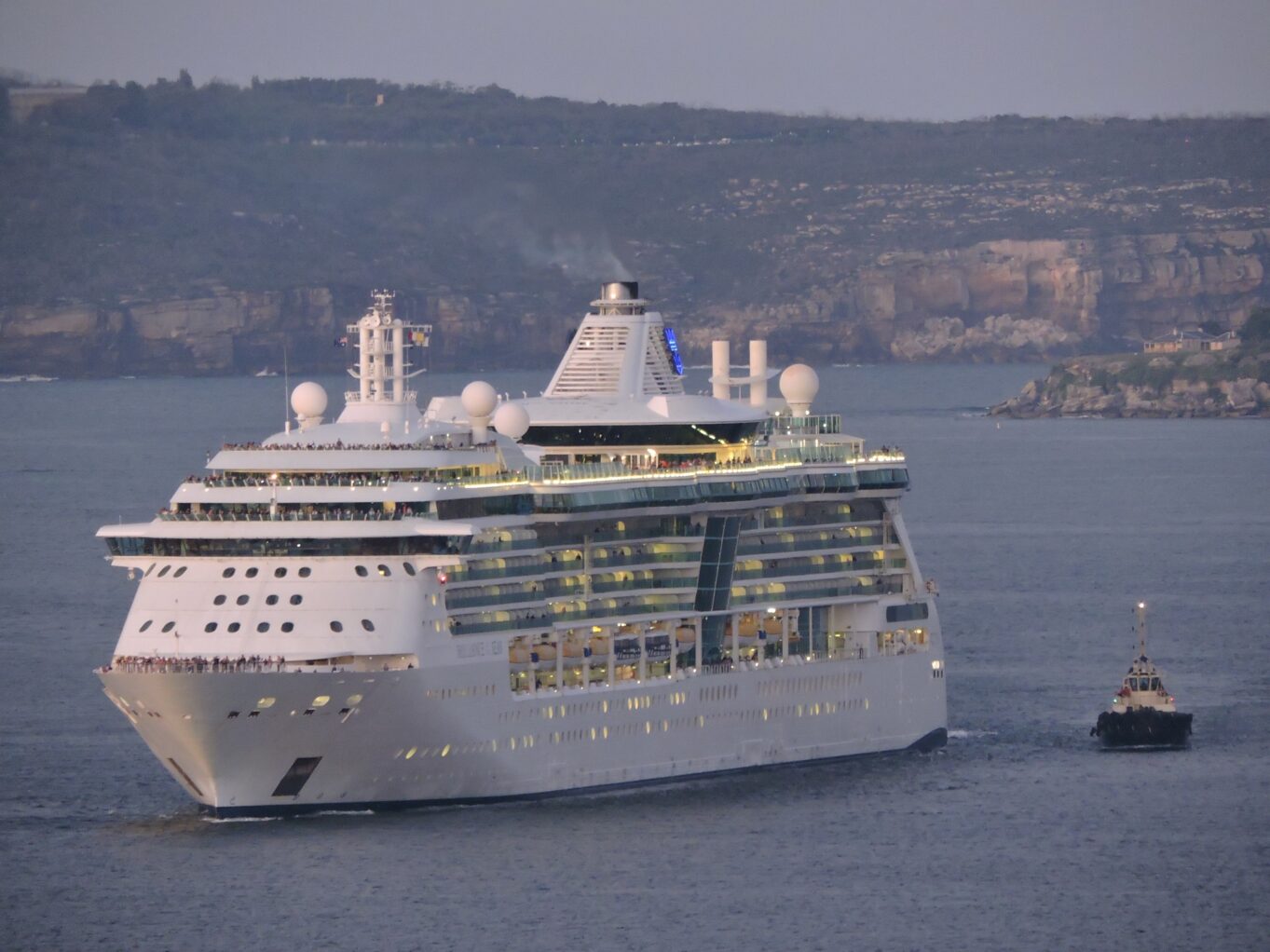 Royal Caribbean’s Brilliance of the Seas is escorted back into Sydney by tugs after experiencing propulsion issues.
