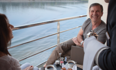 APT couple on the balcony accommodation with their butler pouring coffee