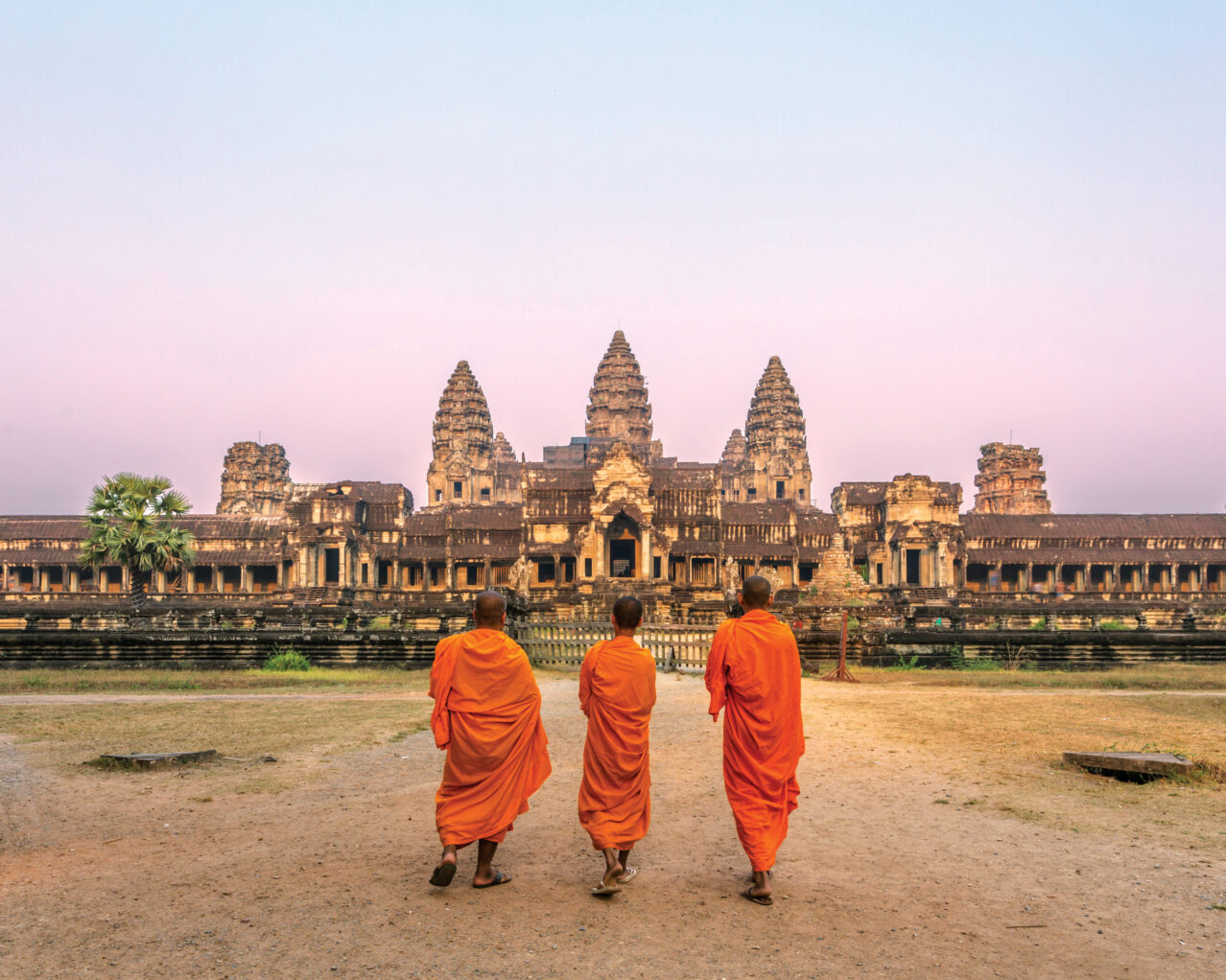 Three monks in front of Angkor Wat in Cambodia