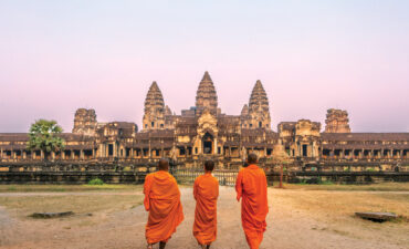 Three monks in front of Angkor Wat in Cambodia on an Avalon Waterways itinerary