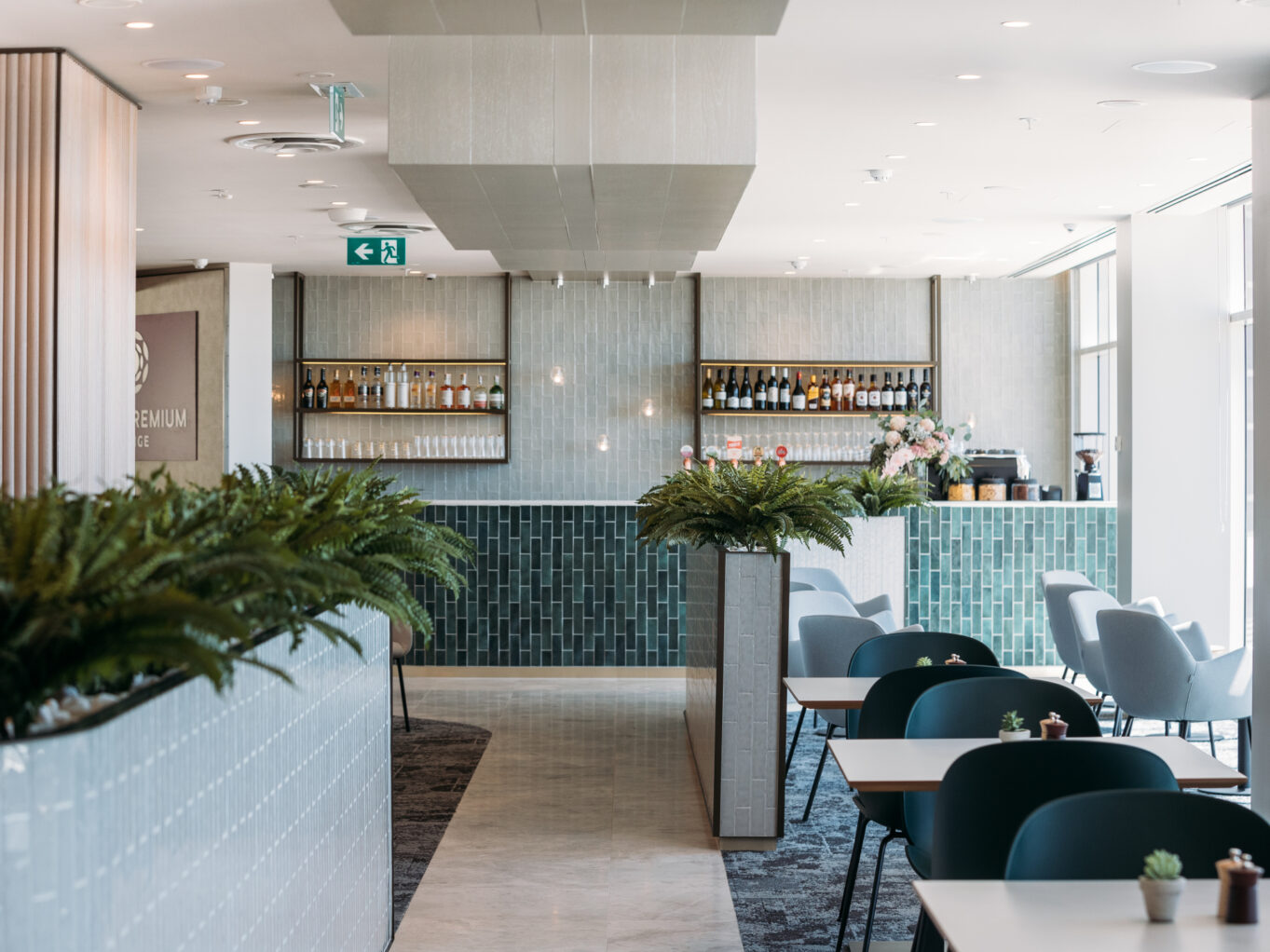 A Premium Lounge with bar and chairs and tables at Sydney Airport.