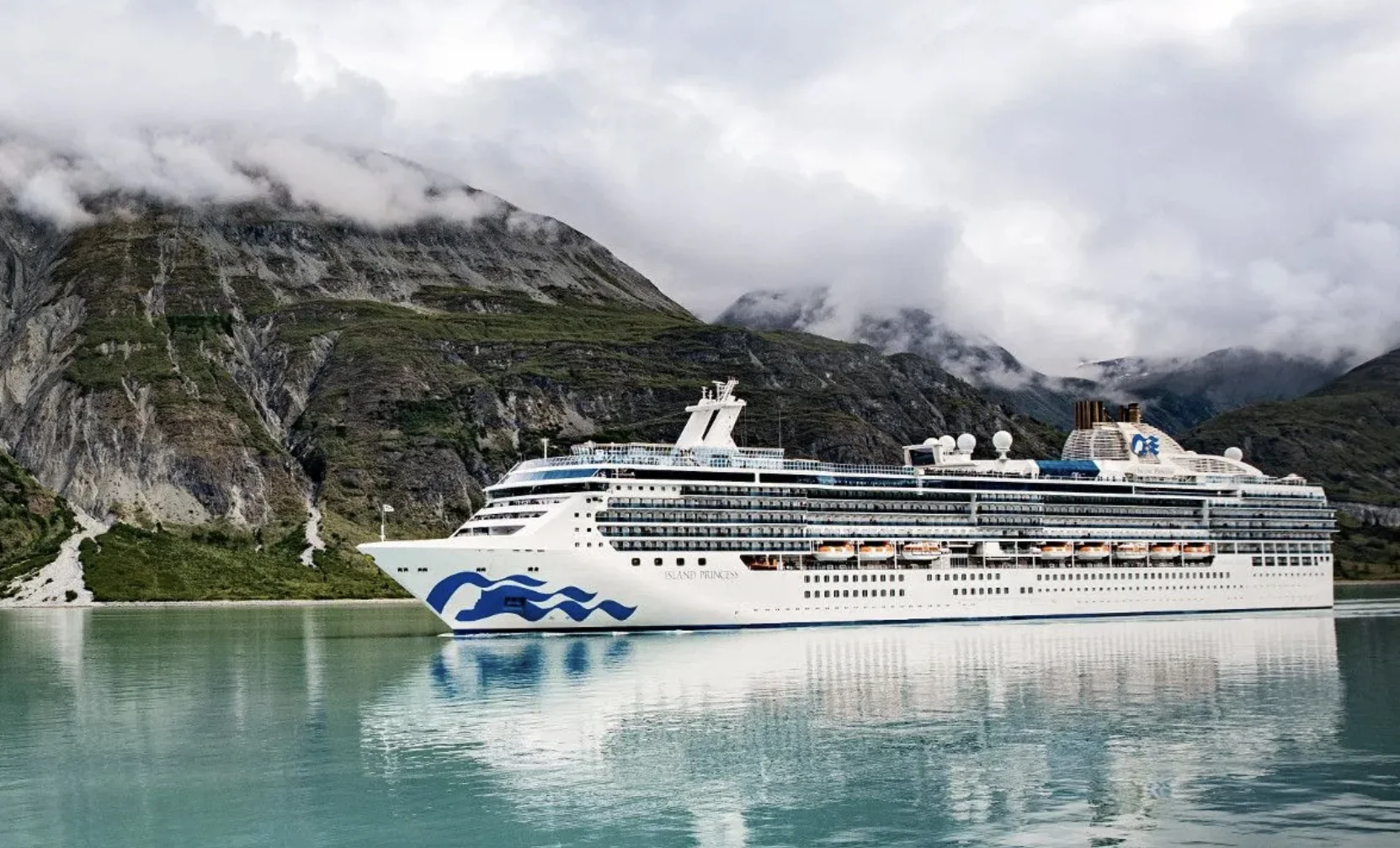 A Princess ship on the water in Alaska floating in front of mountains