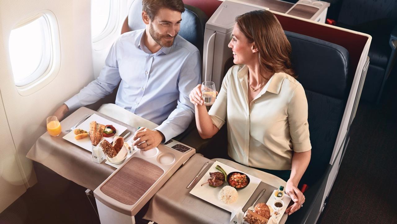 Two people on a Turkish airline flight enjoying a meal