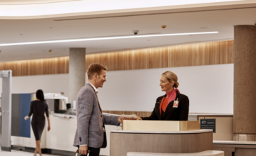 A man ordering flights at the concierge desk.