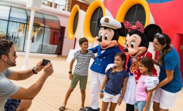 Disney Cruise Line's new season family taking a picture with Mickey and Minnie