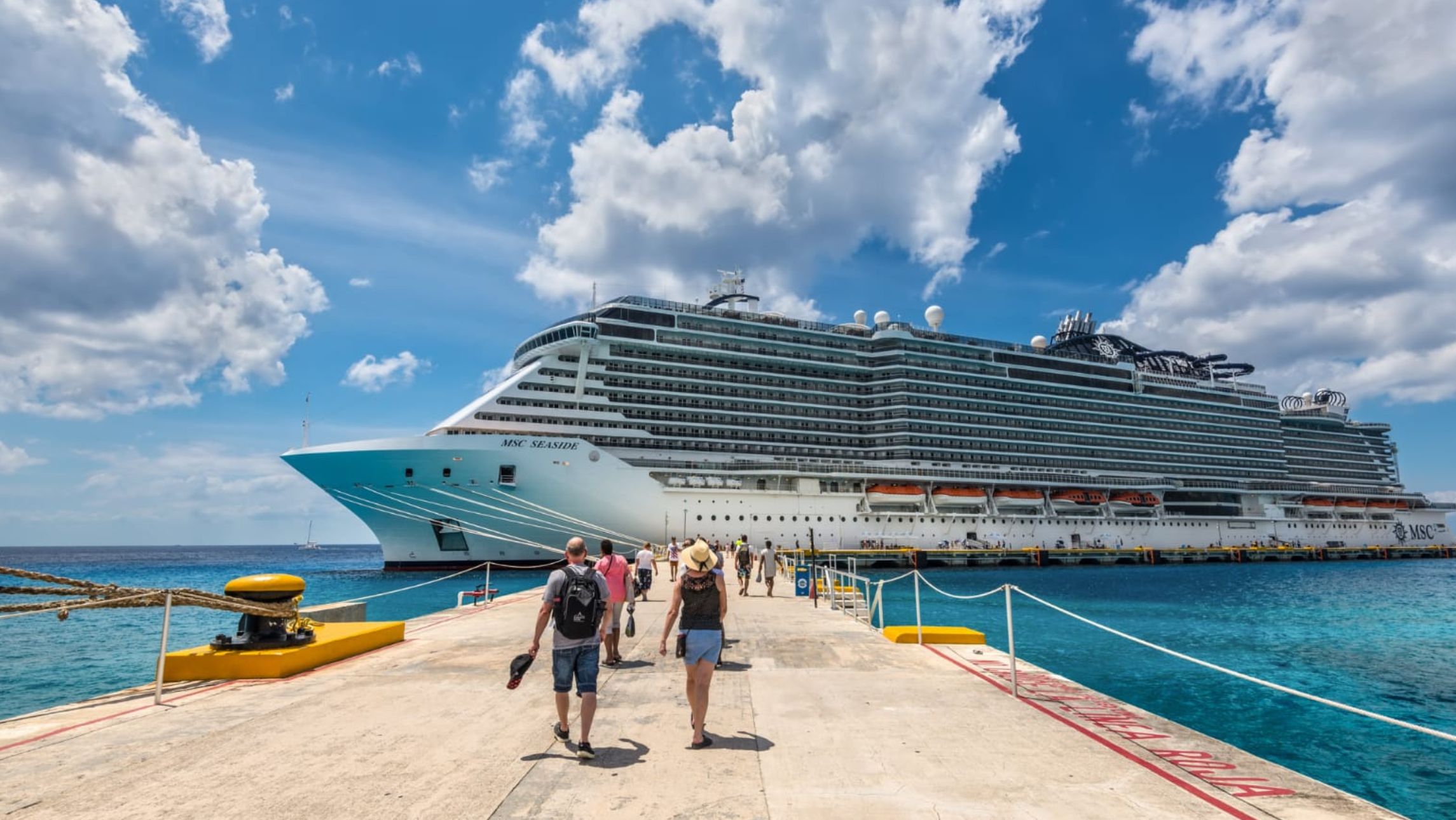 People walking towards a cruise ship in the Caribbean