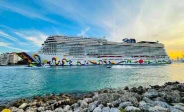 Norwegian Encore sailing in bright blue waters.