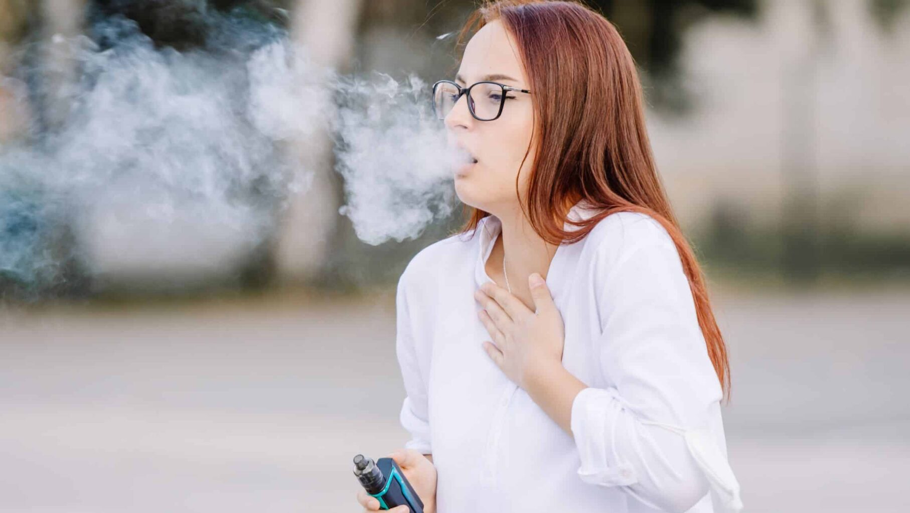 A woman coughs due to her vape.