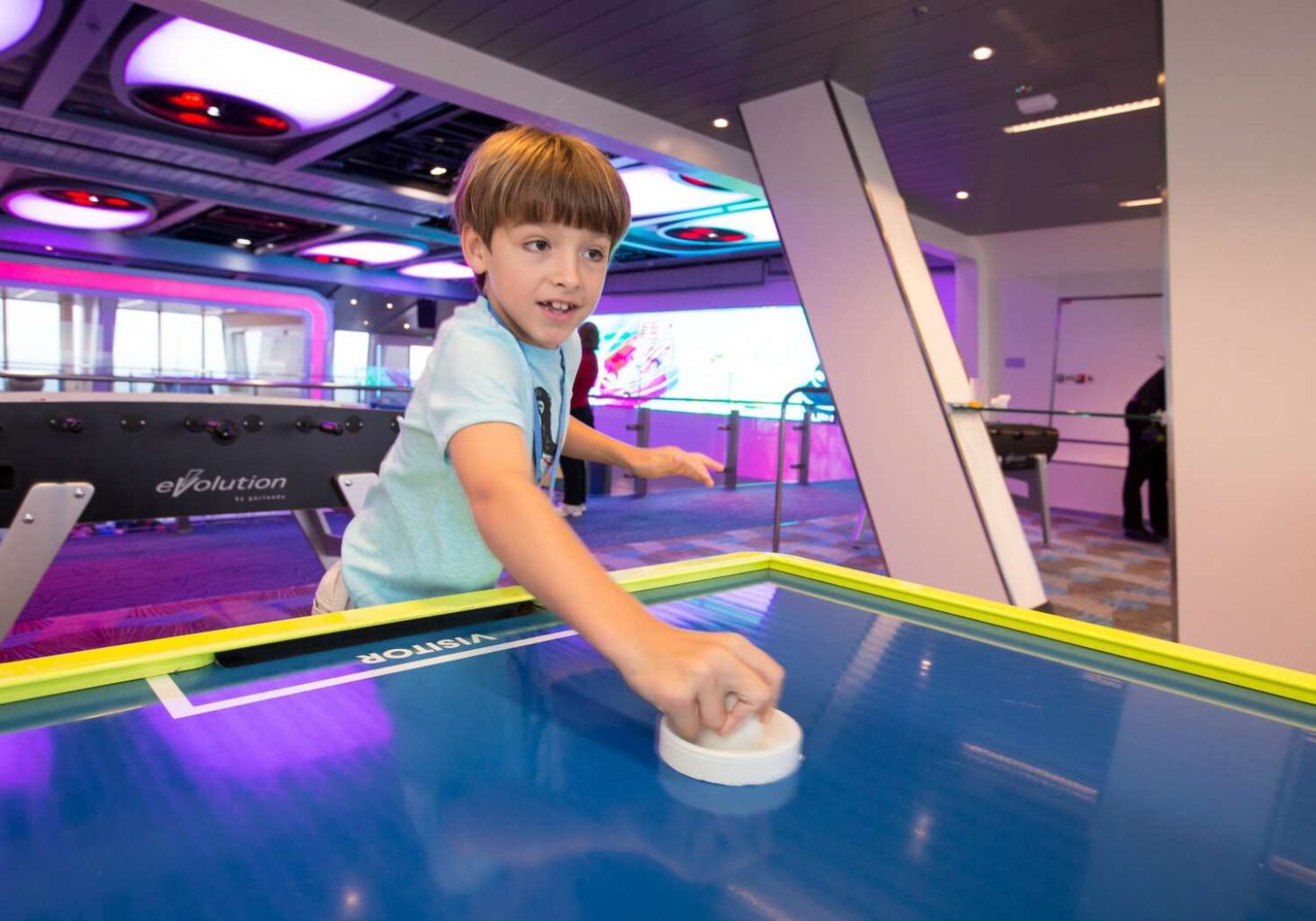 A child on Anthem of the Seas playing air hockey