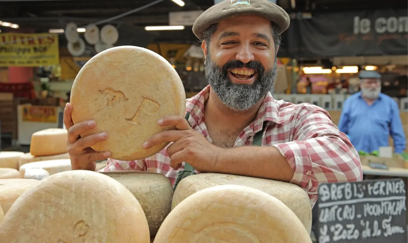 man with cheese in market