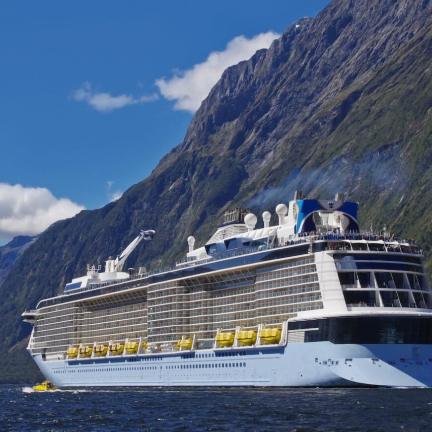 Cruise ship cruises through the mountains at Milford Sound.