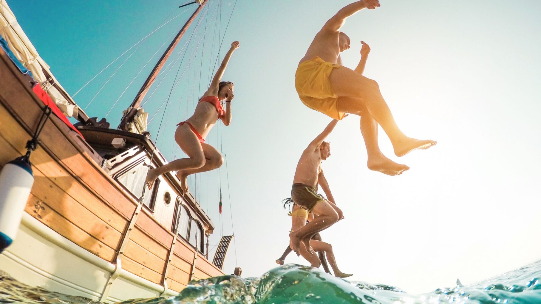 People jumping off a boat into the ocean.