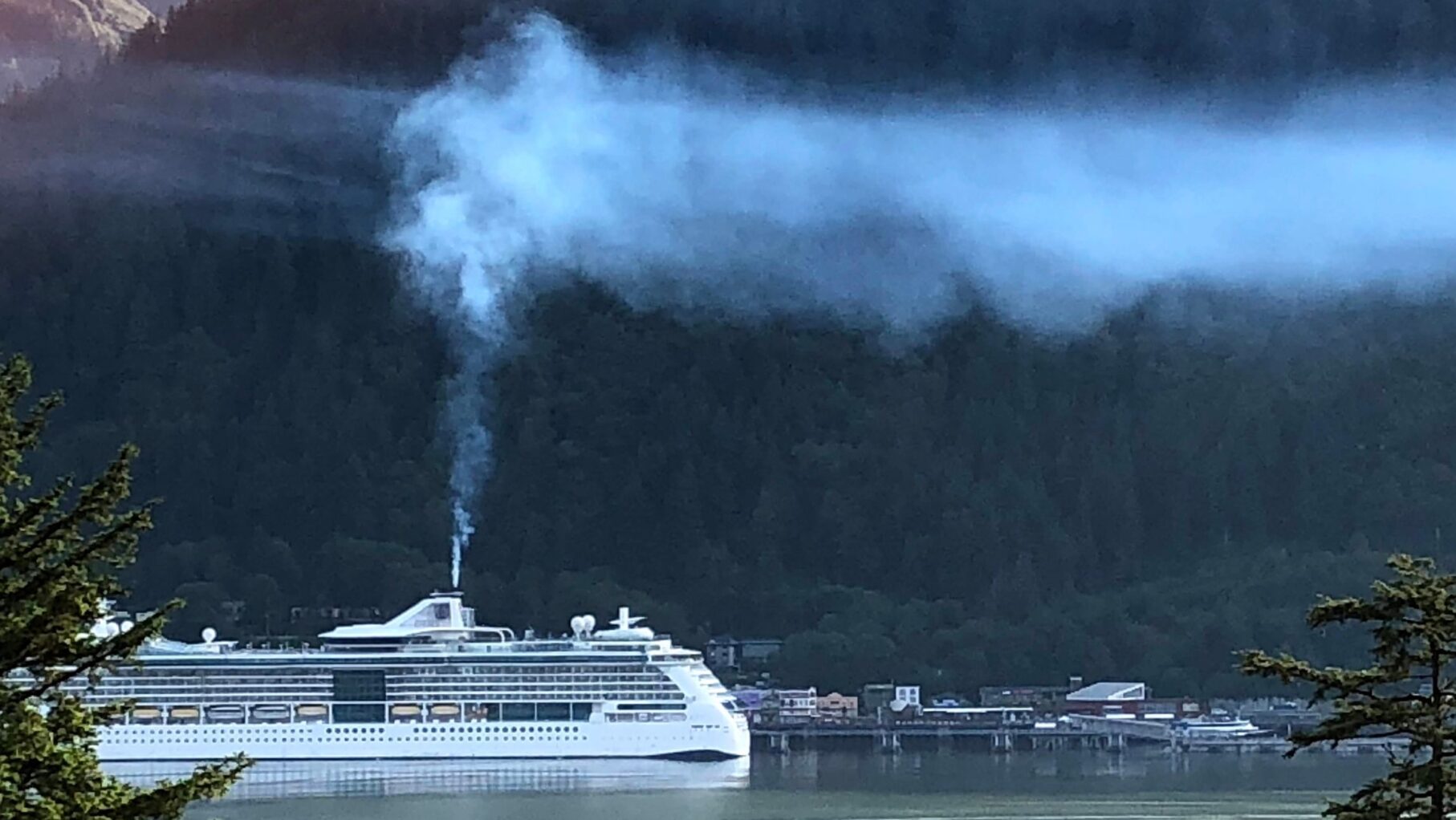 An Alaskan cruise ship sprays smoke.