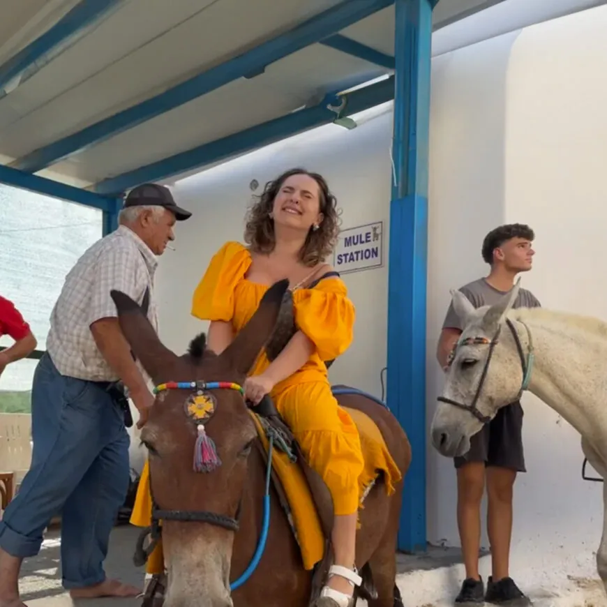 Woman rides Santorini donkeys