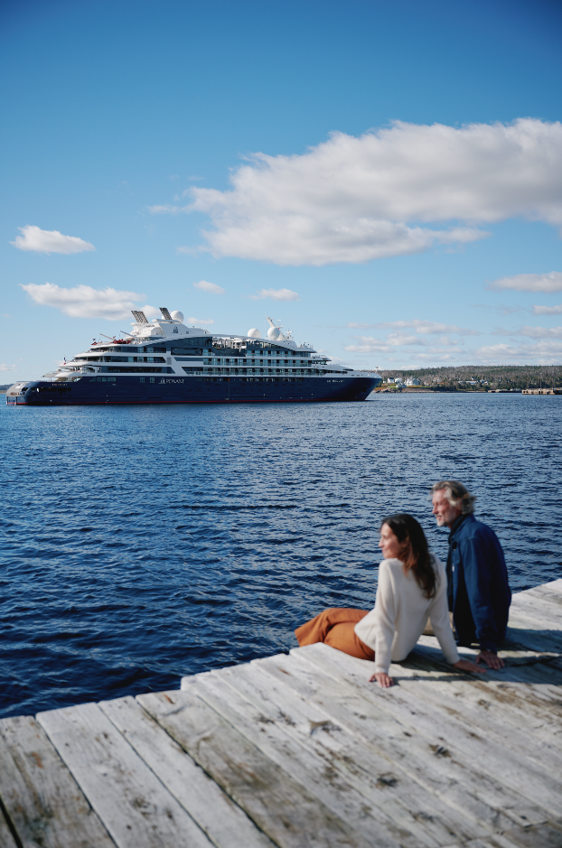 A couple with a Ponant ship in the background