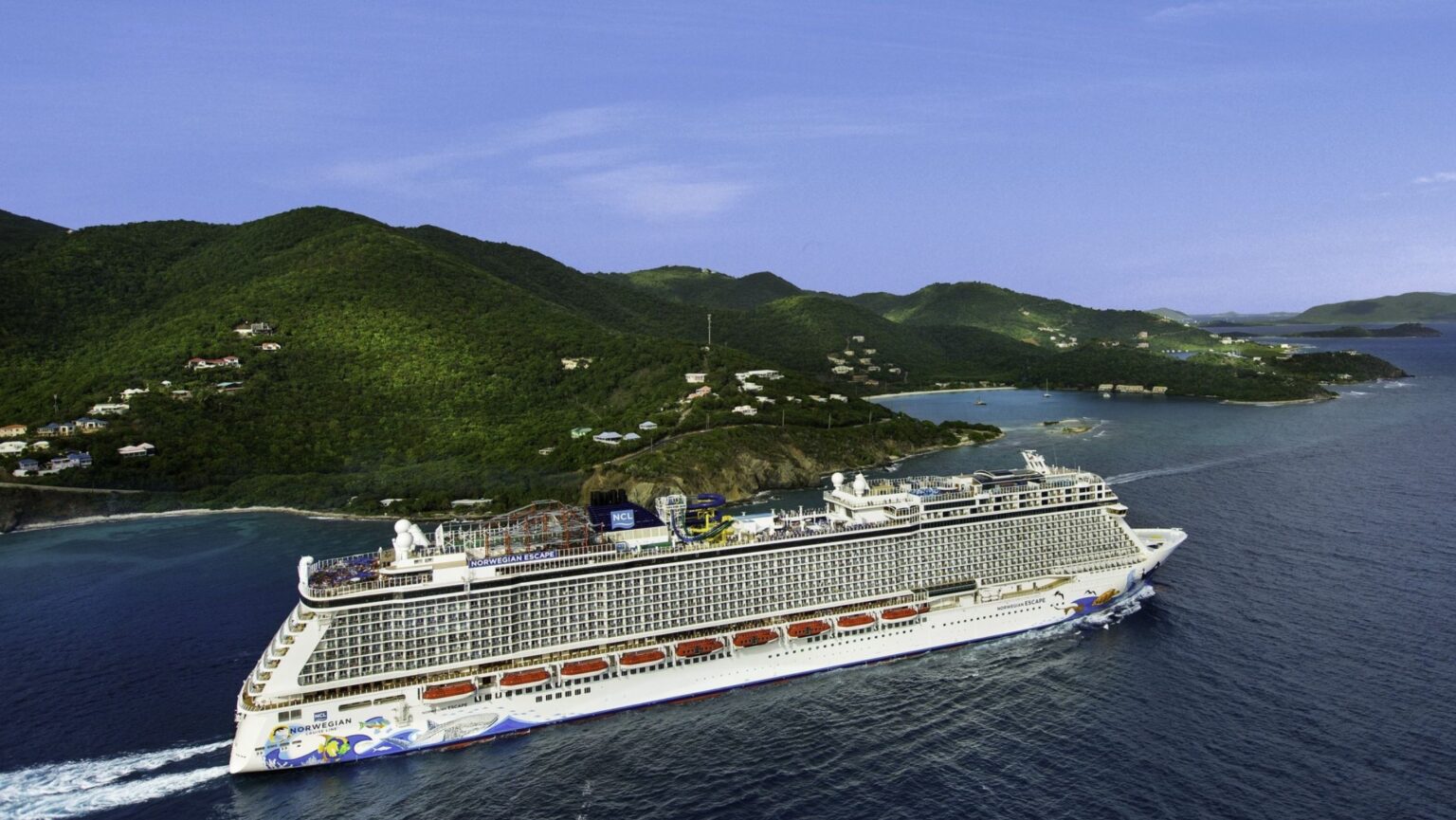 An NCL ship cruising by an island.