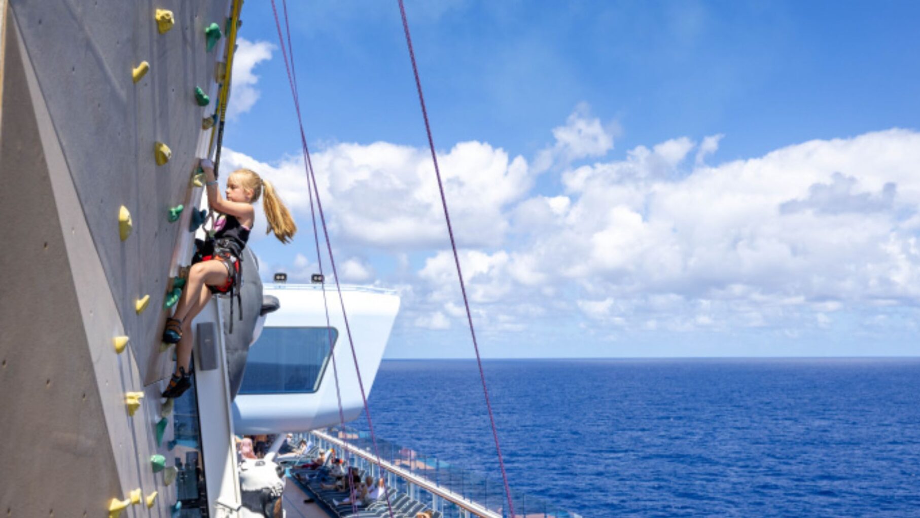 A girl rockclimbing on Ovation of the Seas.