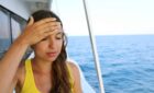 Woman looking unwell on cruise ship.