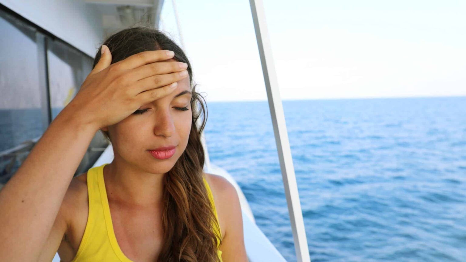 Woman looking unwell on cruise ship.