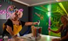 A drag queen handing out ice cream at the Lick Me Till Ice Cream parlour on Virgin Voyages