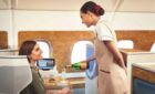 A airline stewardess on Emirates pouring champagn with a passenger