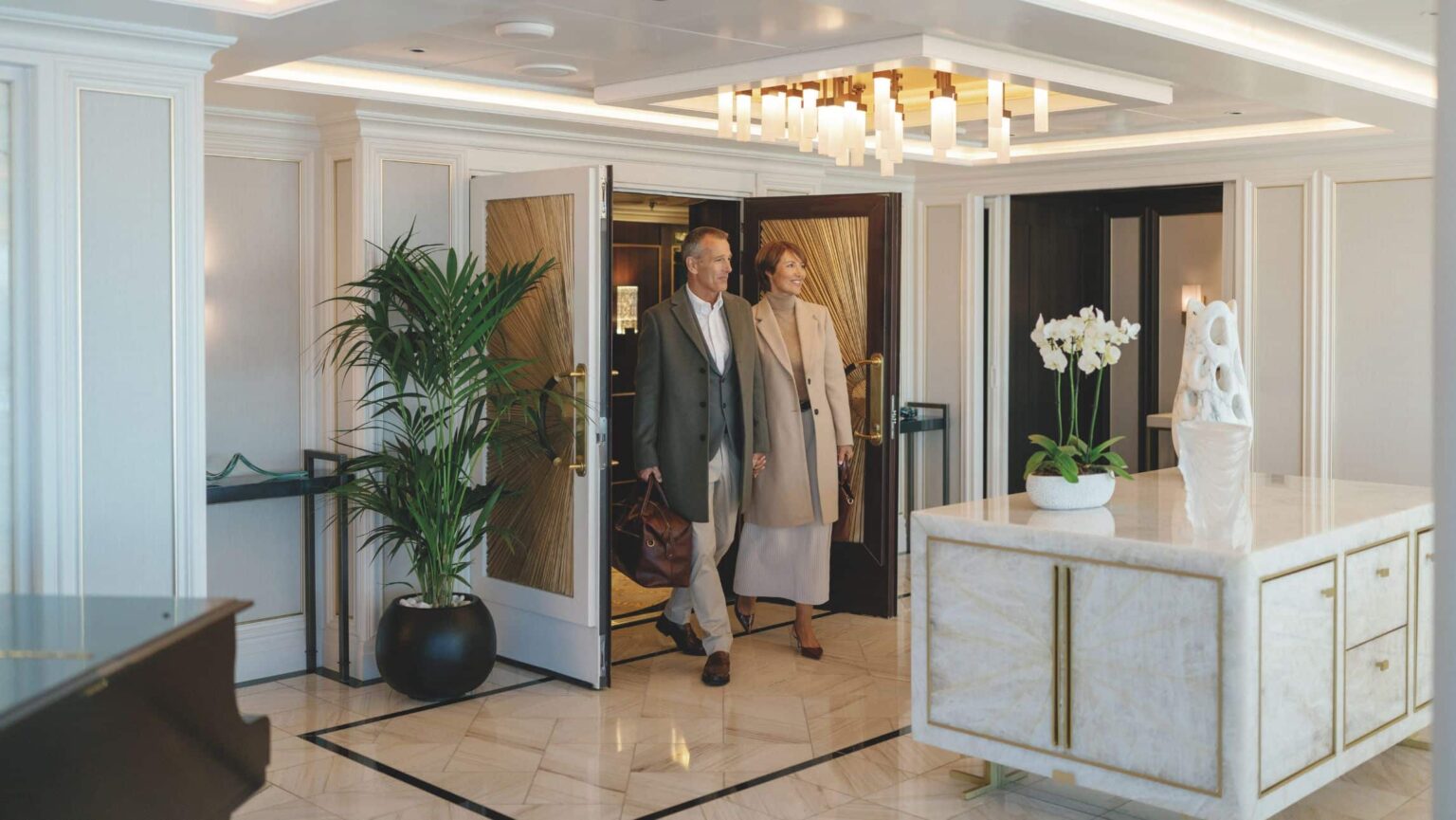 A couple walking into the Owner's Suite on a Regent Seven Seas ship