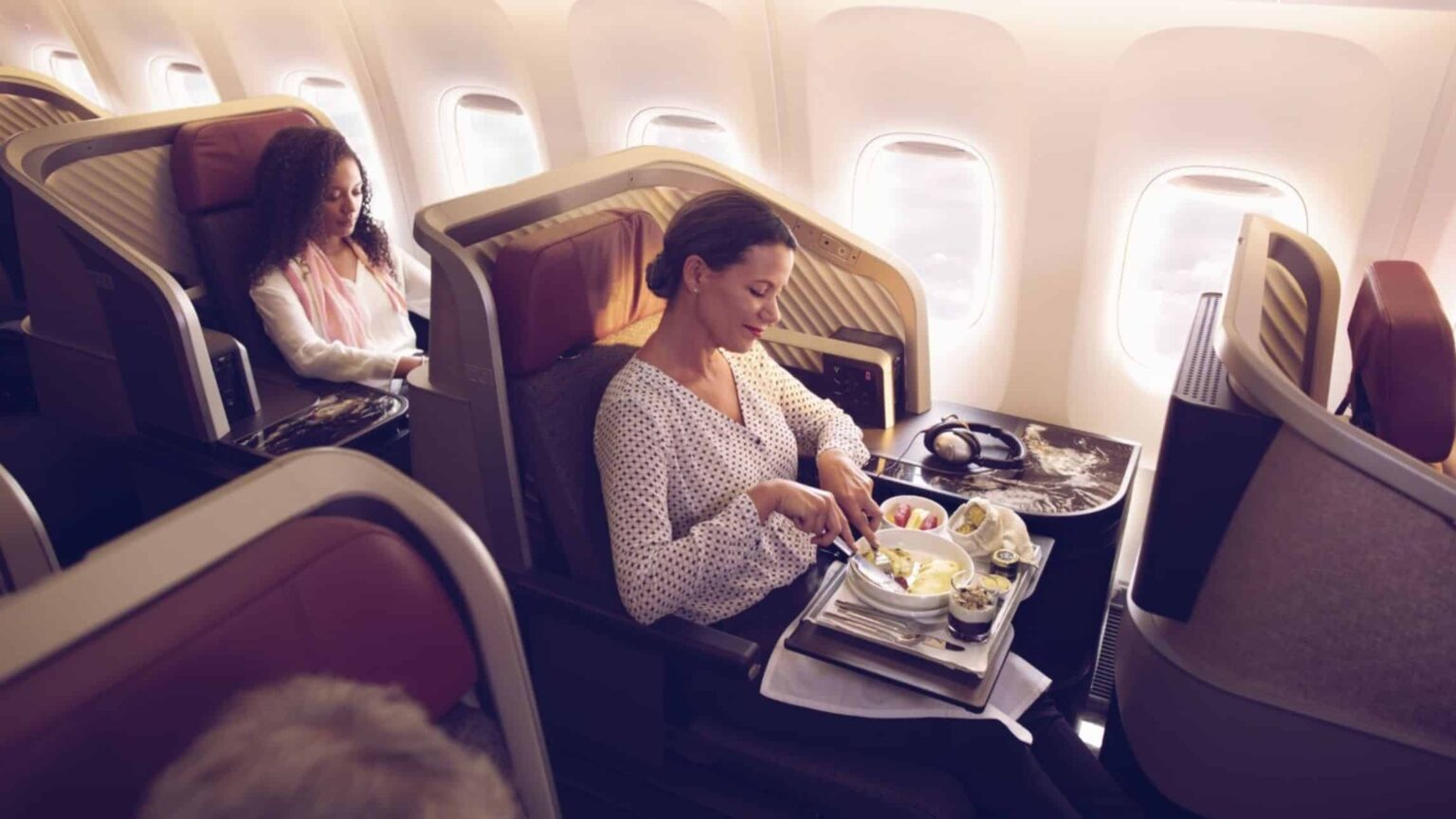 A woman enjoying her dinner on a Latam business class flight