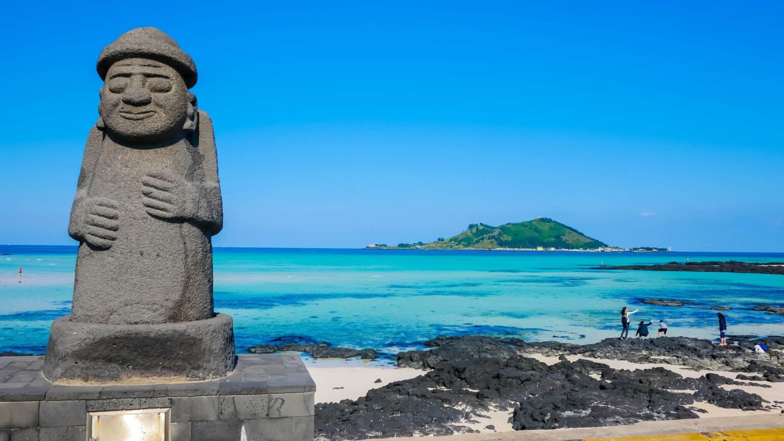 Statue in Jeju with the sea in the background