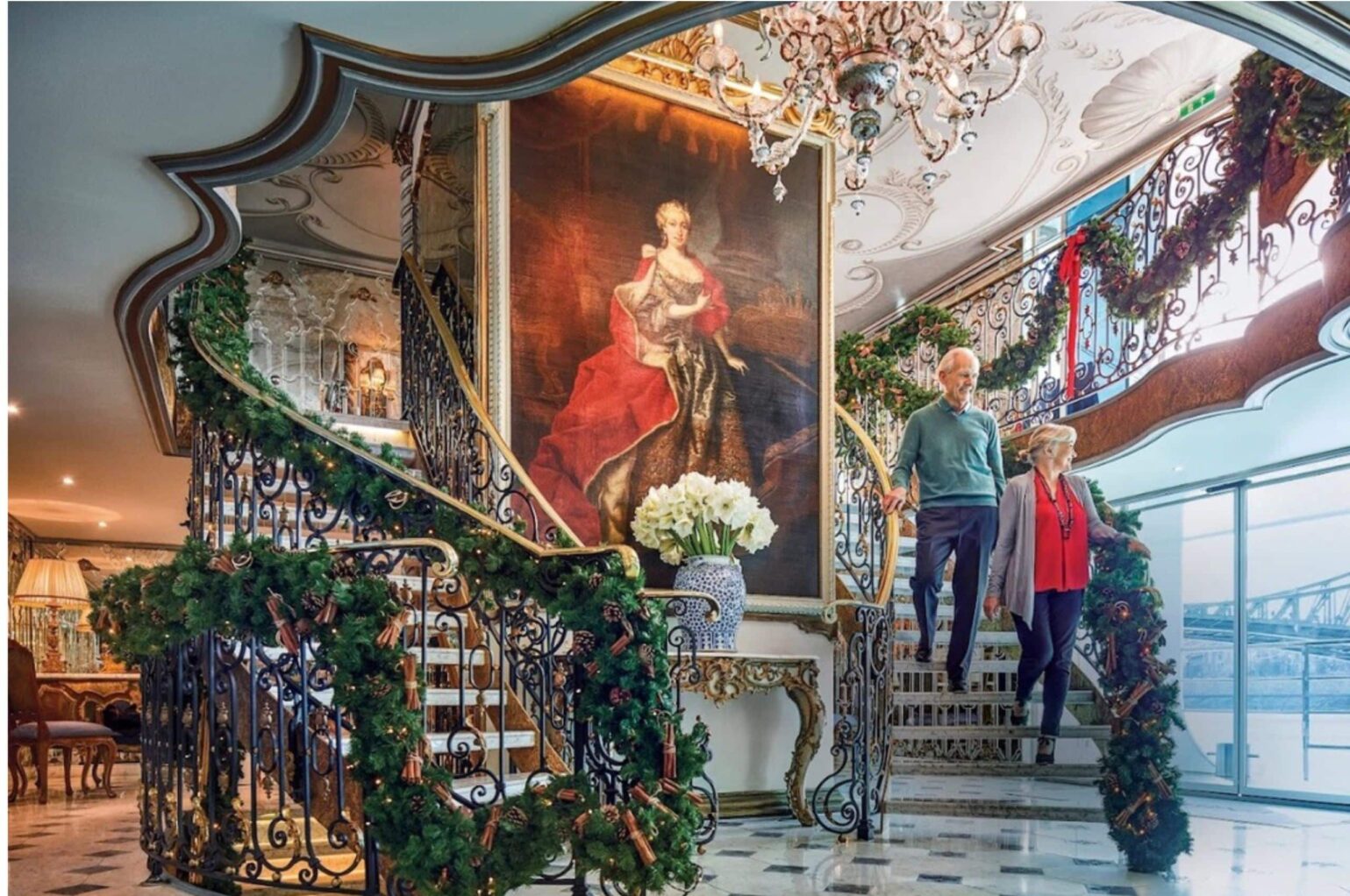 A couple in front of grand art work on a Uniworld cruise ship