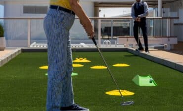Putting on deck a man plays golf on a ship
