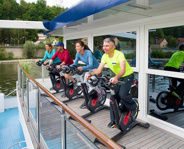 A wellness host taking spin class on AmaWaterways