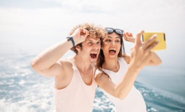 A man and woman in their 20s taking a selfie. Dating on a cruise ship.