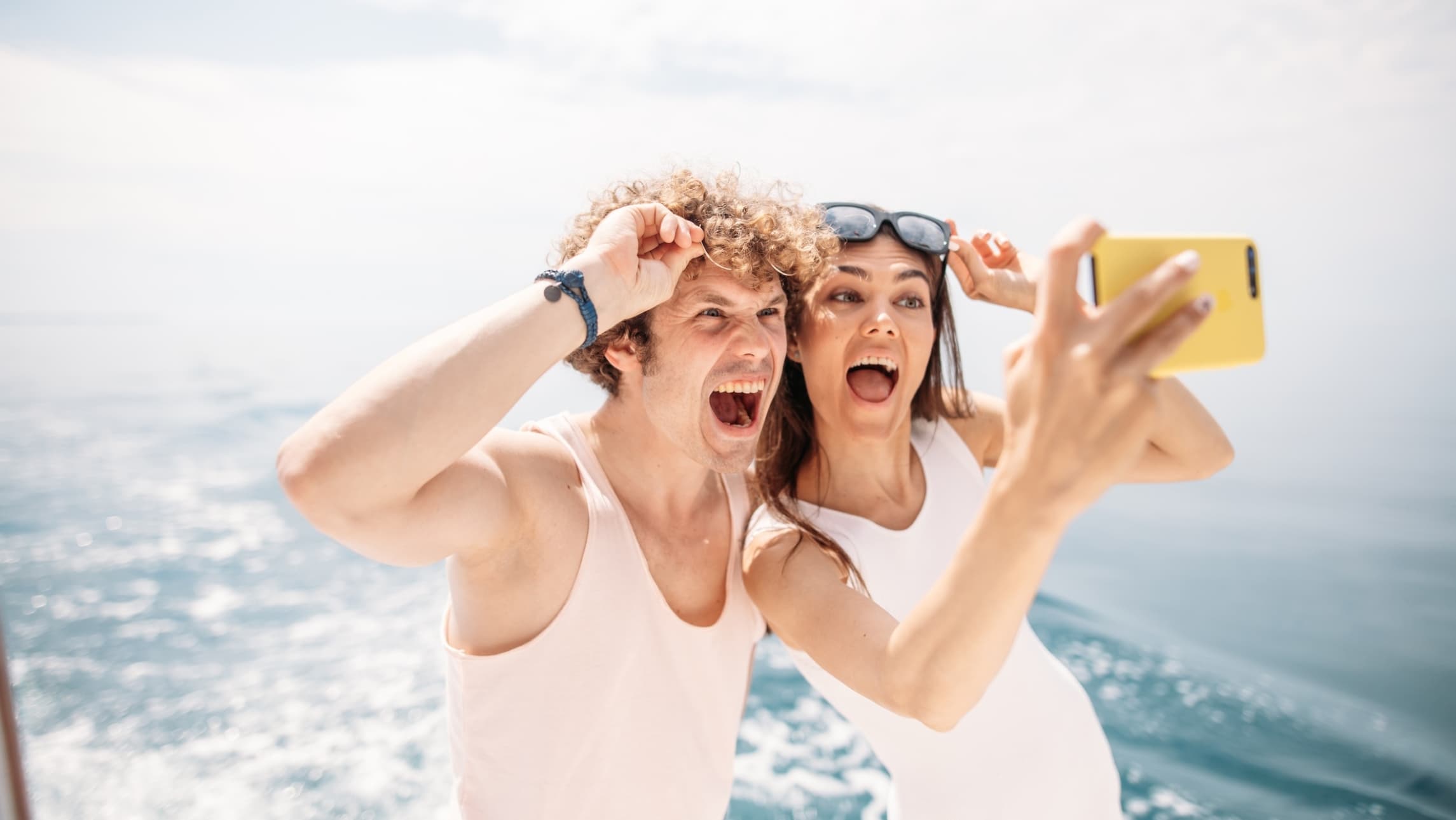 A man and woman in their 20s taking a selfie. Dating on a cruise ship.