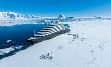 Scenic Eclipse and guest stepping on the fast Ice at Hanusse Bay