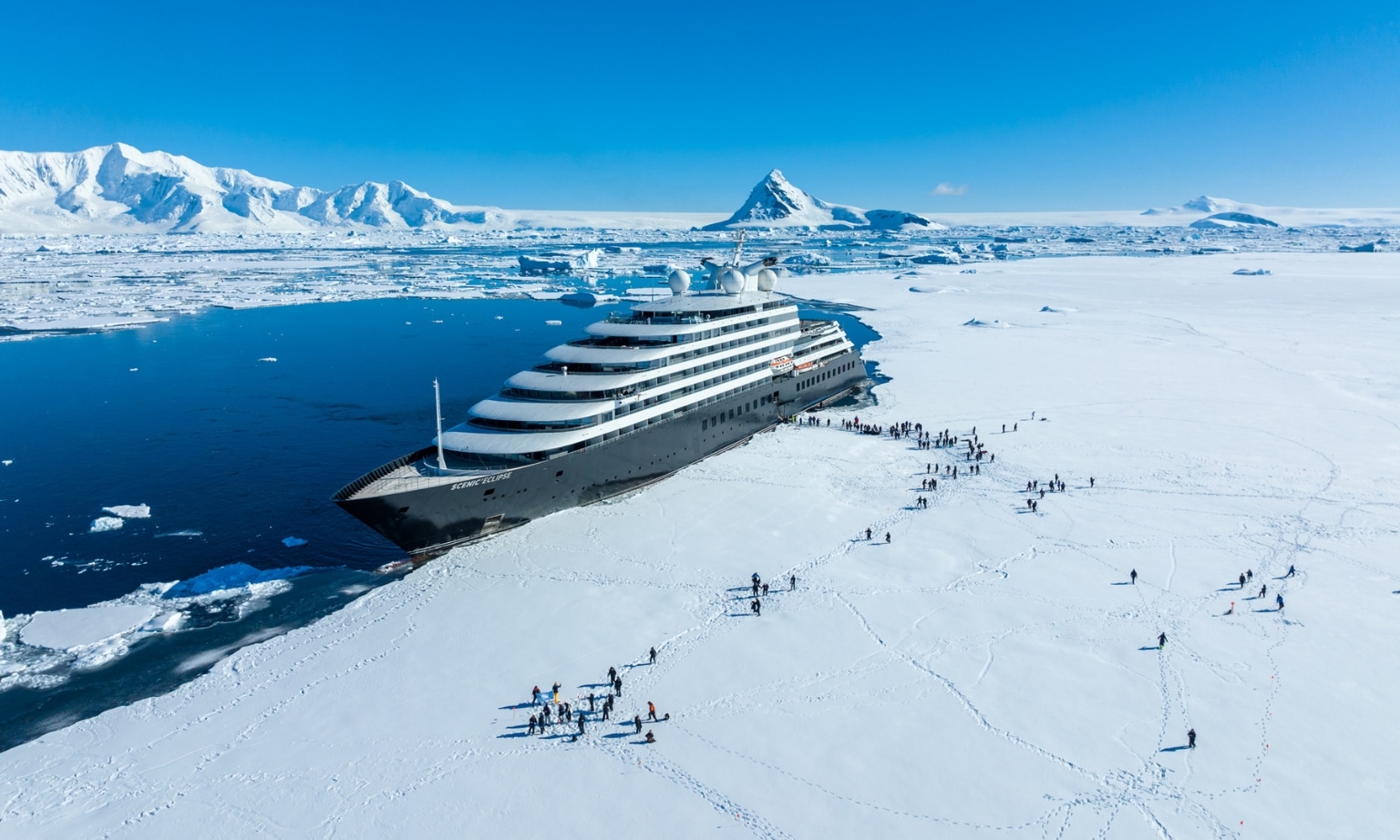 Scenic Eclipse and guest stepping on the fast Ice at Hanusse Bay