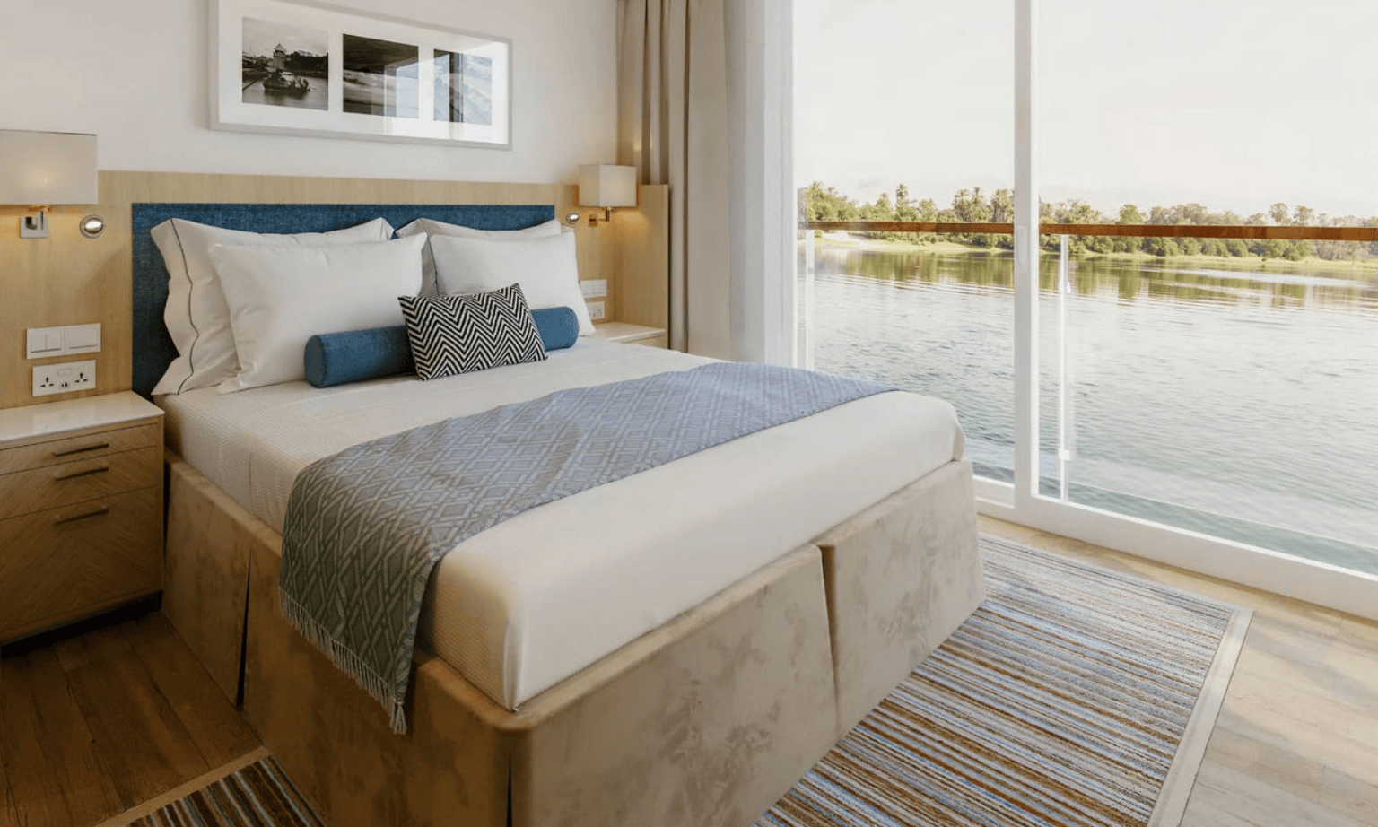 A bed on a cruise ship with water views out the window