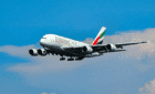 Emirates plane flying with clouds and blue sky