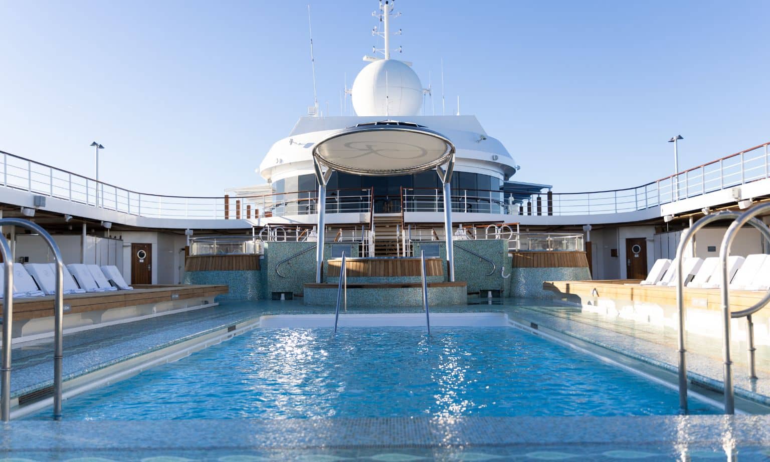 A pool surrounded by sunlounges on the seven seas mariner world cruise